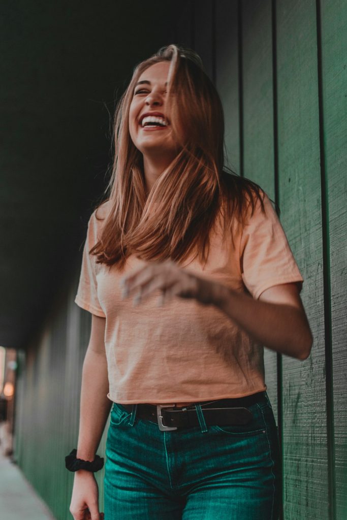 woman-in-orange-shirt-laughing-ospsrnozwia